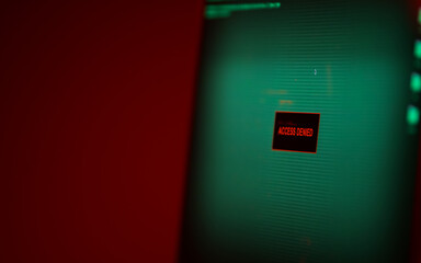 Access denied. Concept photo with a laptop screen showing this message that you are not allowed to view the content. Dark green and red background.