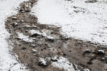 Narrow muddy river in winter park