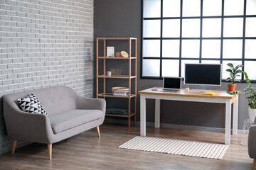 Interior of modern room with workplace and shelving unit