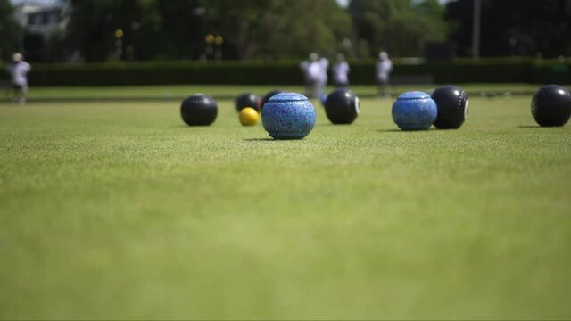 A bowls game being played with anonymous players in the background.