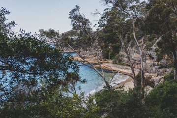 pristine little beach surrounded by rocky cliffs with turquoise water from the Pacific Ocean, seen along the Boronia Beach coastal walk in Tasmania