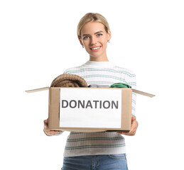 Young woman holding box with clothes for donation on white background