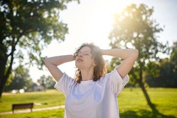 Obraz premium Young girl enjoying a sunny morning in the park