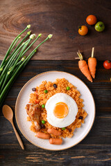 Fried rice with chicken, sausage and fried egg on wooden background, Table top view
