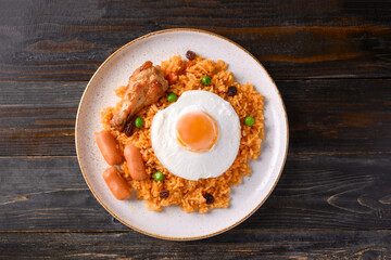 Fried rice with chicken, sausage and fried egg on wooden background, Table top view