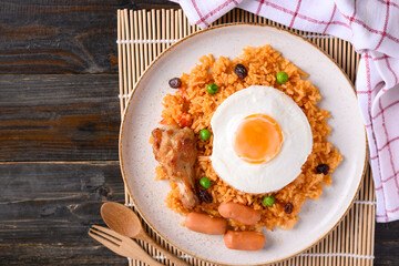 Fried rice with chicken, sausage and fried egg on wooden background, Table top view