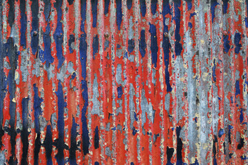 Rusty red blue coloured industrial corrugated iron panel wall detail