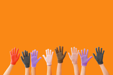 Women in warm gloves on orange background