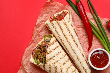 Parchment with tasty burritos and sauce on red background - obrazy, fototapety, plakaty