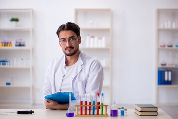 Young male chemist working at the lab