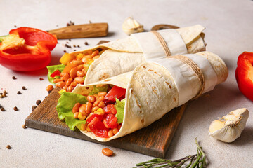 Board with delicious burritos and spices on light background, closeup