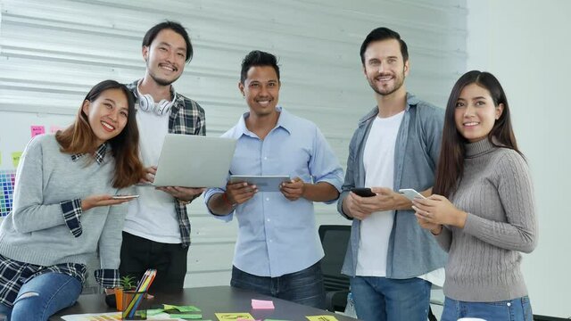 Creative design office center working teamwork. Happy business people partner plan strategy organization research people together at diversity office using laptop, smartphone company conference room