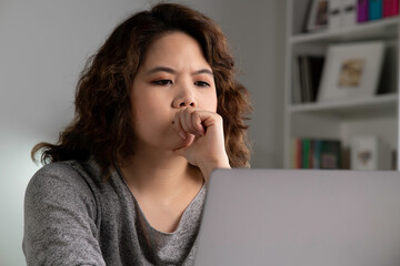 Feeling tired and stressed. Young Asian woman sitting looking deep in thought exhausted and tired...
