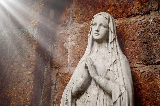Statue of Our lady of grace virgin Mary view with natural background in the rock cave at Thailand. selective focus.