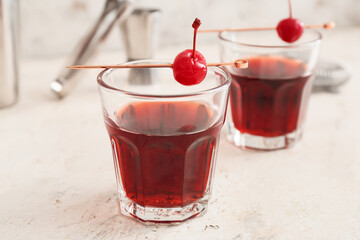 Glass of tasty Manhattan cocktail on light background, closeup