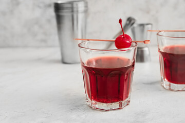 Glass of tasty Manhattan cocktail on light background, closeup