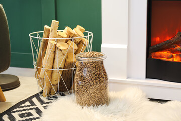 Basket and jar with firewood near mantelpiece in living room