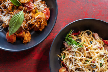 Top view of Chicken macaroni pasta with Spaghetti with chili paste and ham served on red table. Pasta and Spaghetti is made from grain, one of the basic food groups in a healthy diet.