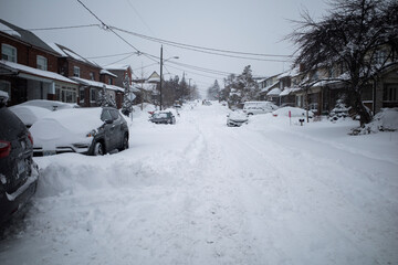 Toronto, Ontario / Canada - January 17, 2022 - Toronto St Clair West sideroad with cars covered on day of snowstorm