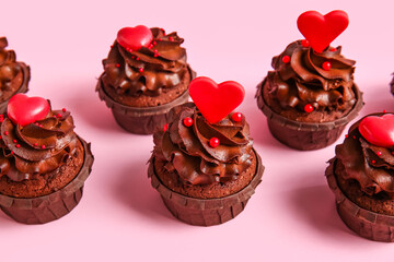 Tasty chocolate cupcakes for Valentine's day on pink background, closeup