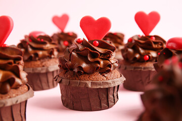 Tasty chocolate cupcakes for Valentine's day on pink background, closeup