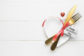 Beautiful table setting and tag with text HAPPY VALENTINE'S DAY on white wooden background
