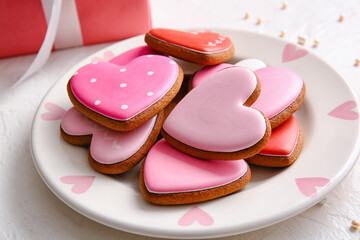 Plate with tasty heart shaped cookies on white background
