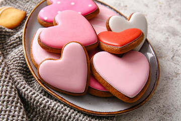 Plate with tasty heart shaped cookies on light background