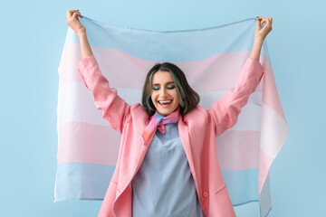 Beautiful young woman with unusual hair and transgender flag on color background - obrazy, fototapety, plakaty