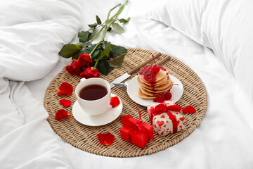 Beautiful roses, breakfast and presents for Valentine's Day on soft bed