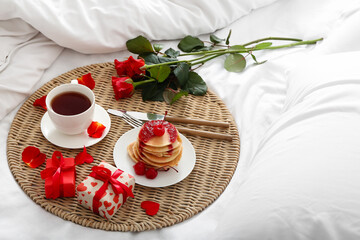 Beautiful roses, delicious breakfast and presents for Valentine's Day on soft bed