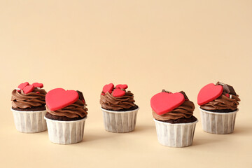 Tasty chocolate cupcakes for Valentine's Day on beige background