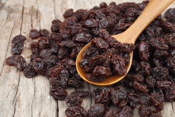 Organic dried Raisins in wood spoon on old wooden table background