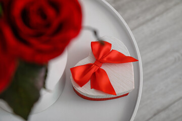 Gift and rose flowers for Valentine's Day on table in room, top view