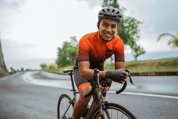 Foto auf Acrylglas happy smiling road bike cyclist while riding his bike outdoor © Odua Images