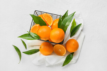 Basket with fresh juicy oranges on white background