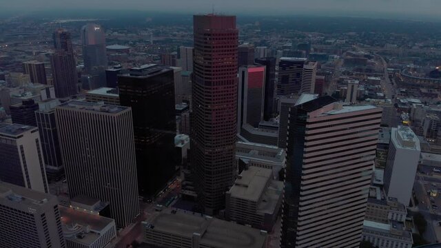 Slow tilting down rise over tall buildings in downtown Denver Colorado (filmed above adjacent building, height legal per part 107)