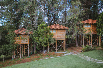 Una casa hecha de elementos de madera a lado de los arboles.