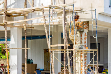 Close up Workers industrial bricklayer installing bricks is under construction, remodeling, renovation, extension, restoration and reconstruction.