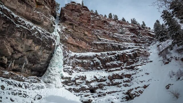 Time lapse, Frozen Waterfall and Clouds Moving Above Cliff in a Cold White Snowy Winter Landscape of Outay, Colorado USA