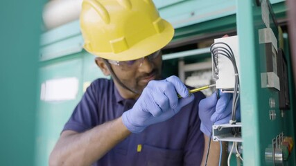 Focus on hand, young electrical engineer with protective workware repairing or connecting wires by using screw driver at workplace - Concept of hard working, Skilled rapair man with safety precautions