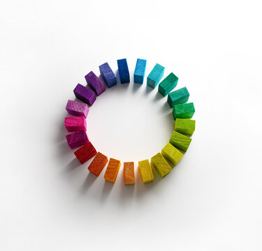 Colors in unity. Circle of colored blocks representing unity of diverse elements (colors). .Wooden blocks placed in a a circle on a neutral white background, with natural shadows.