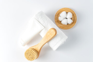 Fototapeta na wymiar natural bristle massage brush for body brushing, towel and body scrub on white background. natural bristle for removing of cellulite and stimulating lymphatic system. Tools for spa