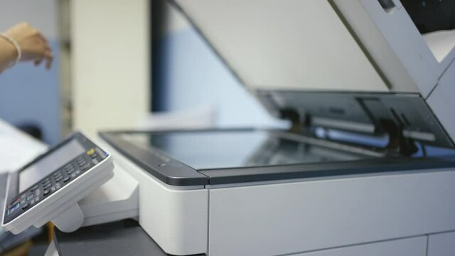 Hand of woman is using a photocopier to copy documents.
