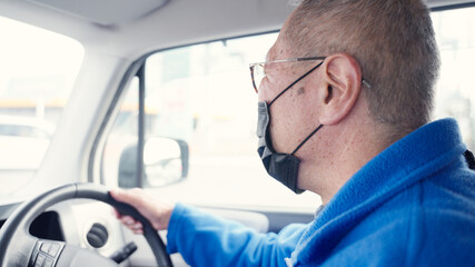 自動車を運転するシニアの男性