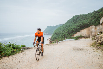 Fototapeta premium road bike cyclist riding his bike on a cliff