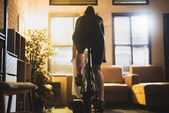 Asian woman cyclist. She is exercising in the house.By cycling on the trainer and play online bike games
