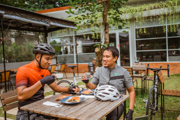 two cyclist enjoying coffee in the cafe after riding