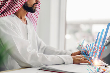 Portrait of arabic success arab businessman using technology of laptop looking at progress of business financial investment data graph and chart business growth increase at office