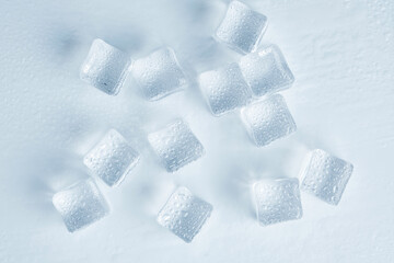 Ice cubes are covered with water droplets on a white background.